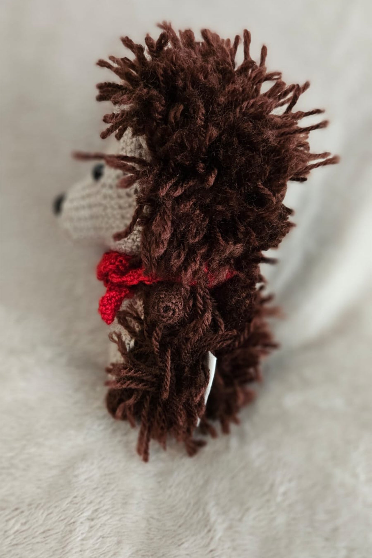 Seitenprofilansicht vom gehäkelten Igel Henry mit flauschigen Stacheln